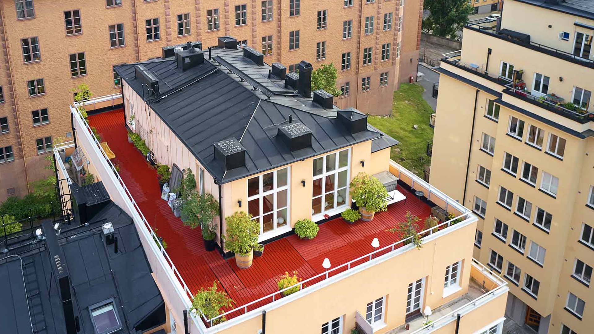 Ombyggnation med ny takterrass och plåtomläggning , svart plåttak, gul fasad och rött terass, Verkstadsvägen 5, Stockholm. Foto Martin Ekwall.