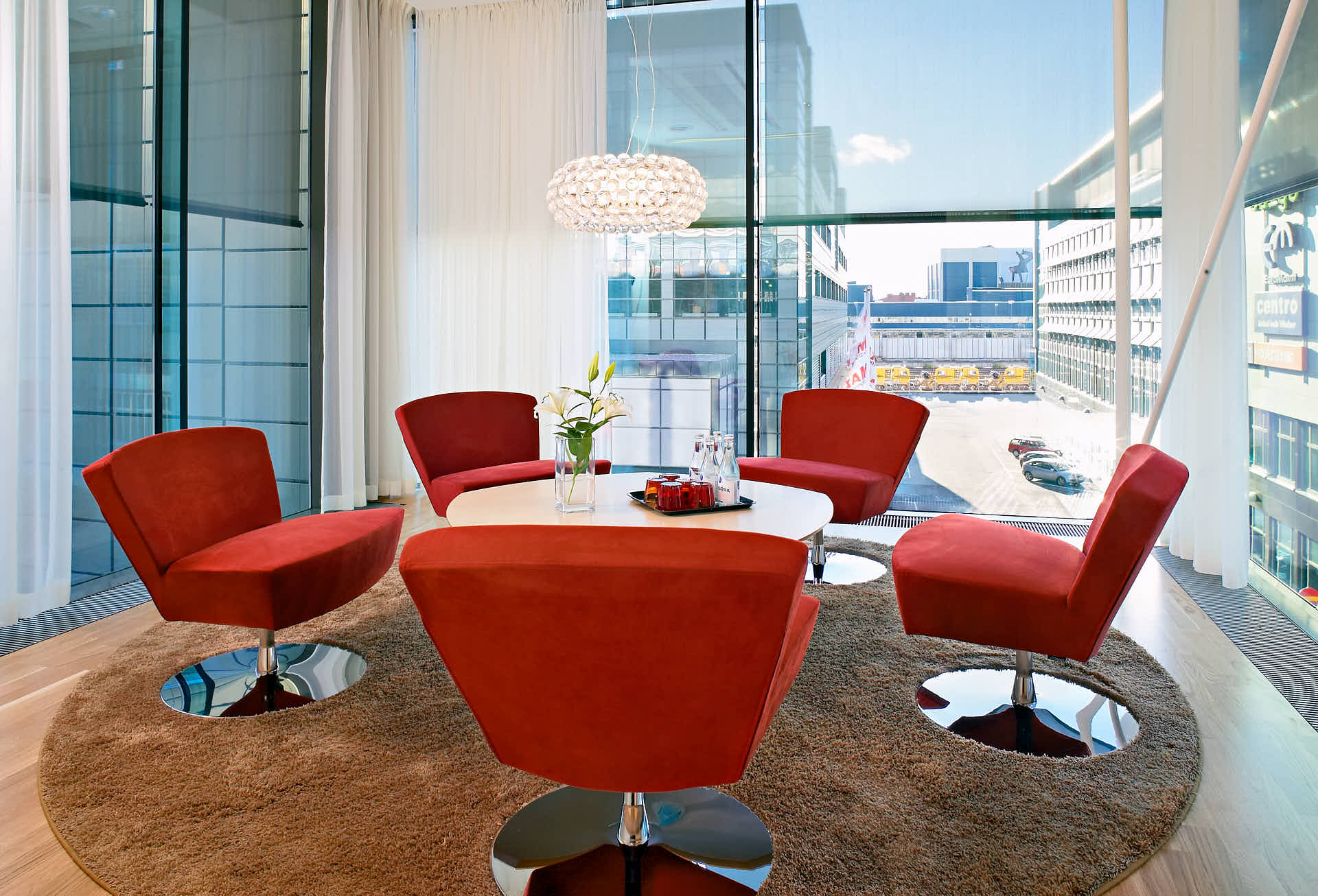 Spaciöst arbetsrum i burspråk med röda fåtöljer i Solna Business Centre, foto av Martin Ekwall