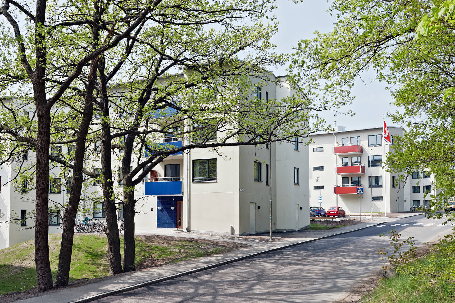 Flerbostadshus utmed gata och nygrönskande trän i Sickla Sjö, Stena Fastigheter, foto av Martin Ekwall