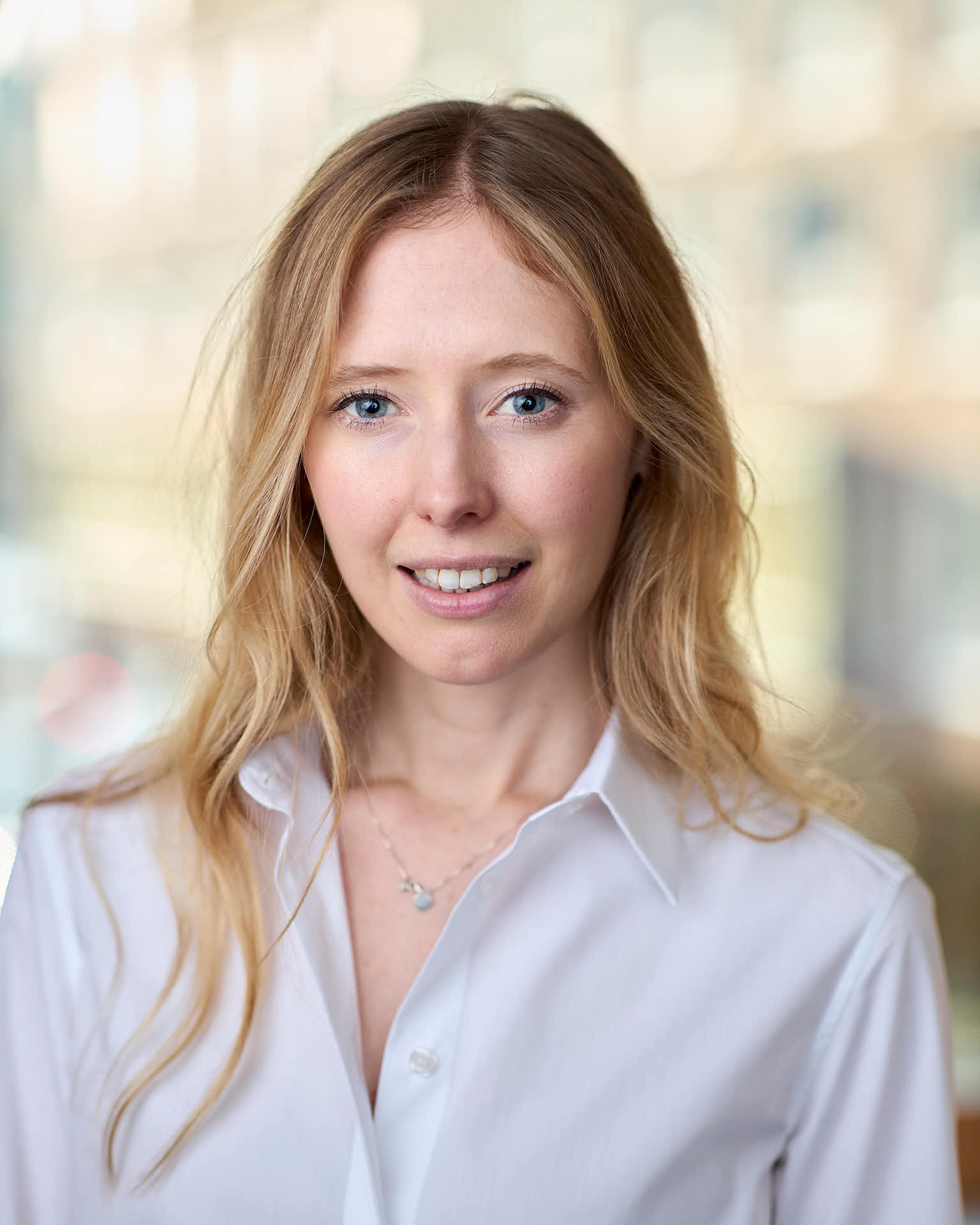 Porträtt av Caroline Banefelt vid fönster hos Case Kapitalförvaltning i Stockholm. Fotograferad av Martin Ekwall.