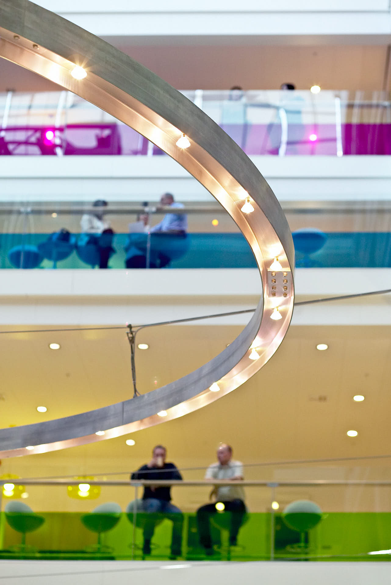 Co-Pilot byggde Coops huvudkontor i Solna, detalj av rund lampa i atrium, våningar med olika färger, foto av Martin Ekwall.