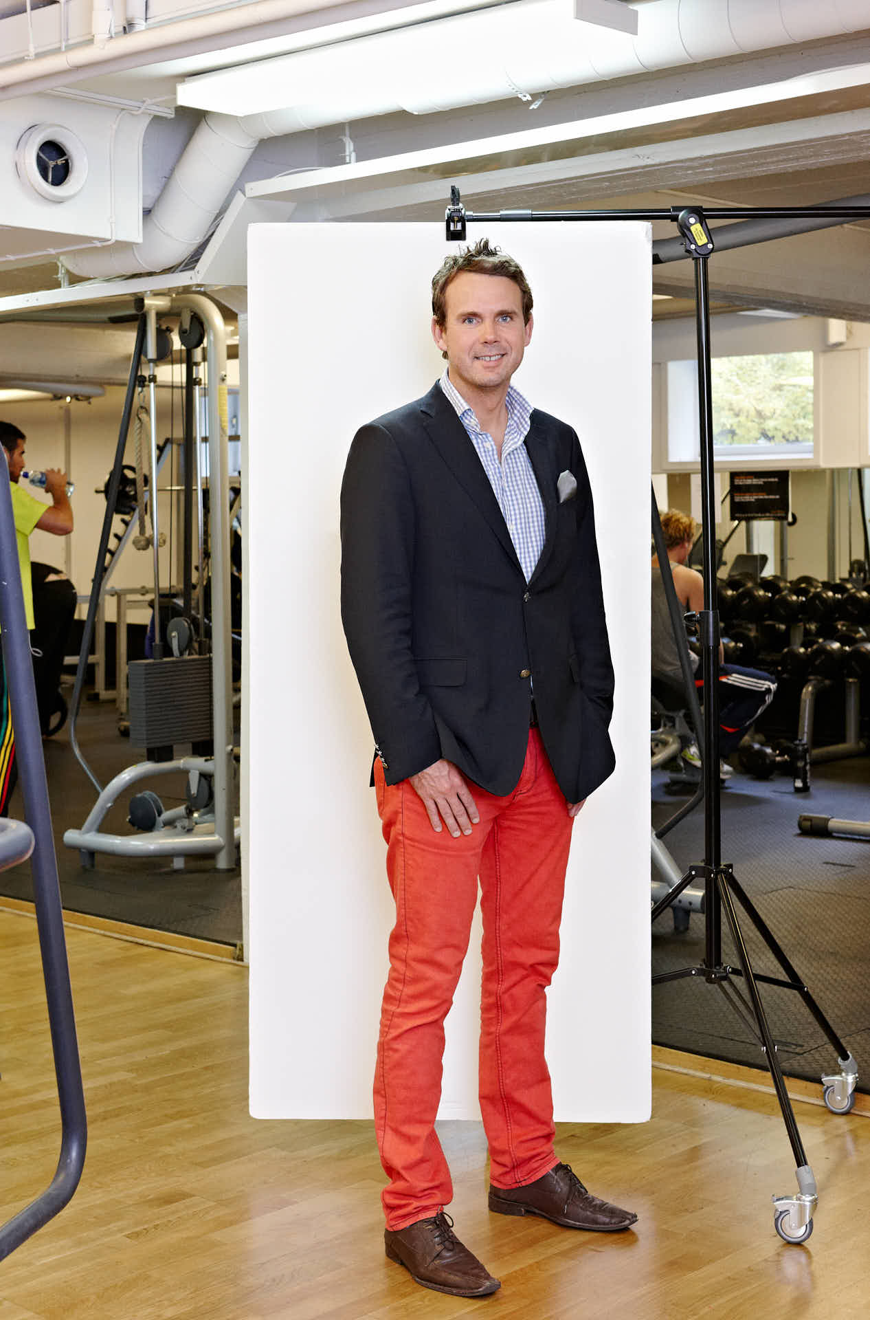 Jonas Permevik från Fitness24Seven poserar vid vit bakgrund med gymmiljö i bakgrunden efter UGL-utbildning på Gällöfsta Herrgård & Konferens. Foto-Martin Ekwall