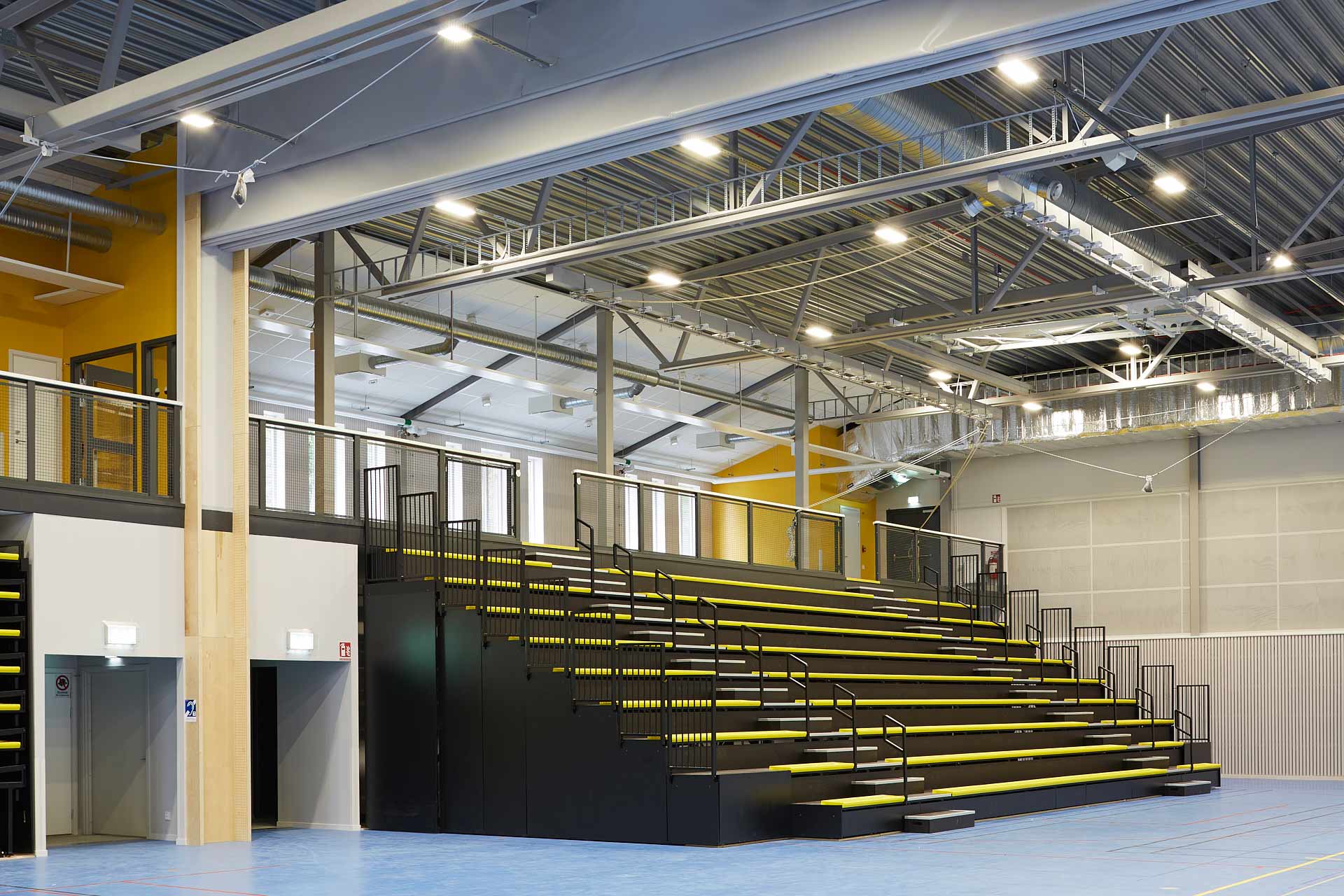 Ekebyhovs sporthall på Ekerö: läktare med sittplatser och belysning i sporthallen. Byggd av In3prenör, ritad av Comarc Arkitekter. Foto Martin Ekwall.