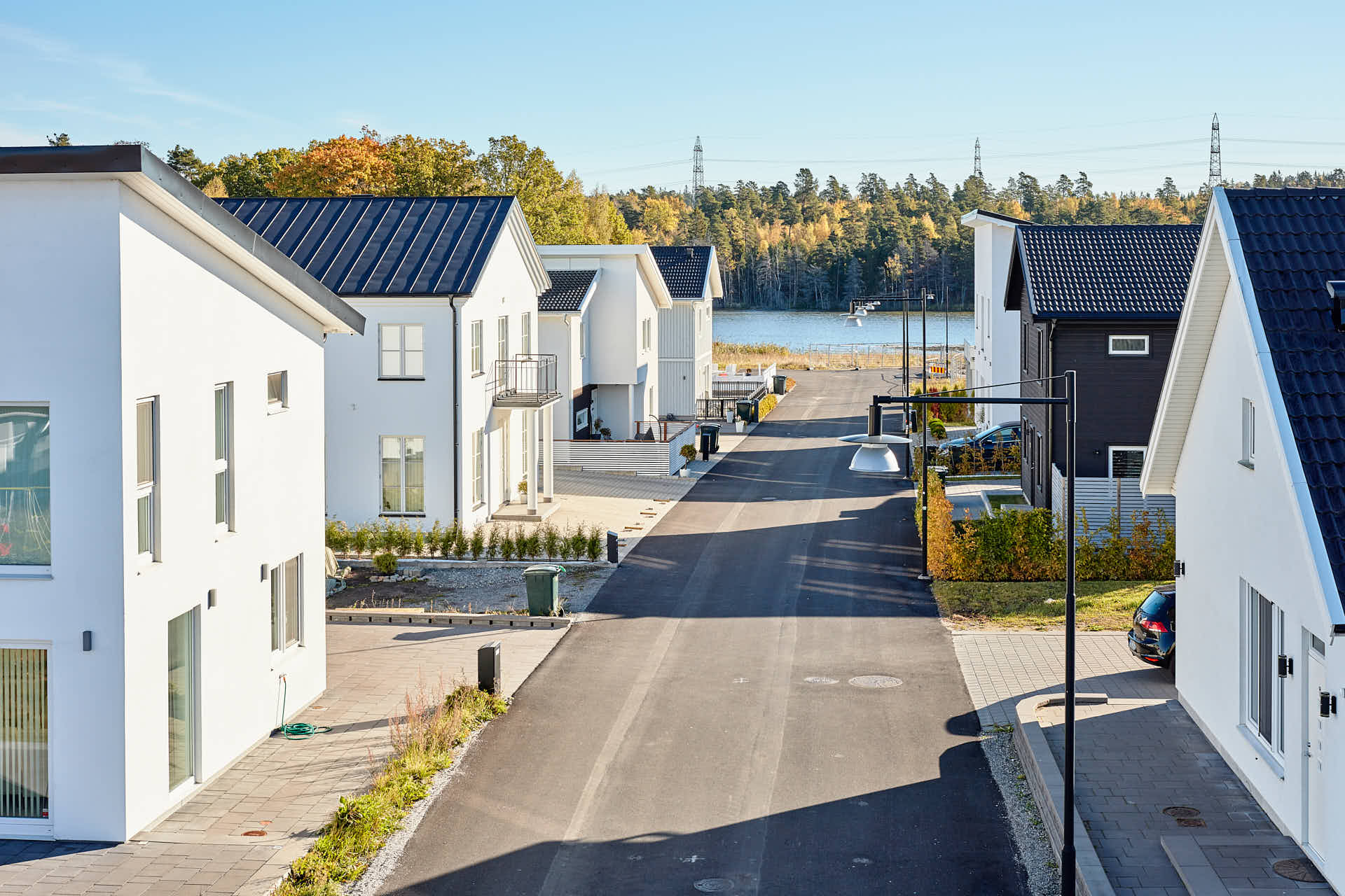 Gata fågelvy med vita villor mot en sjö,  Glasberga Sjöstad i Södertälje. Kund Paradoumo, foto av Martin Ekwall