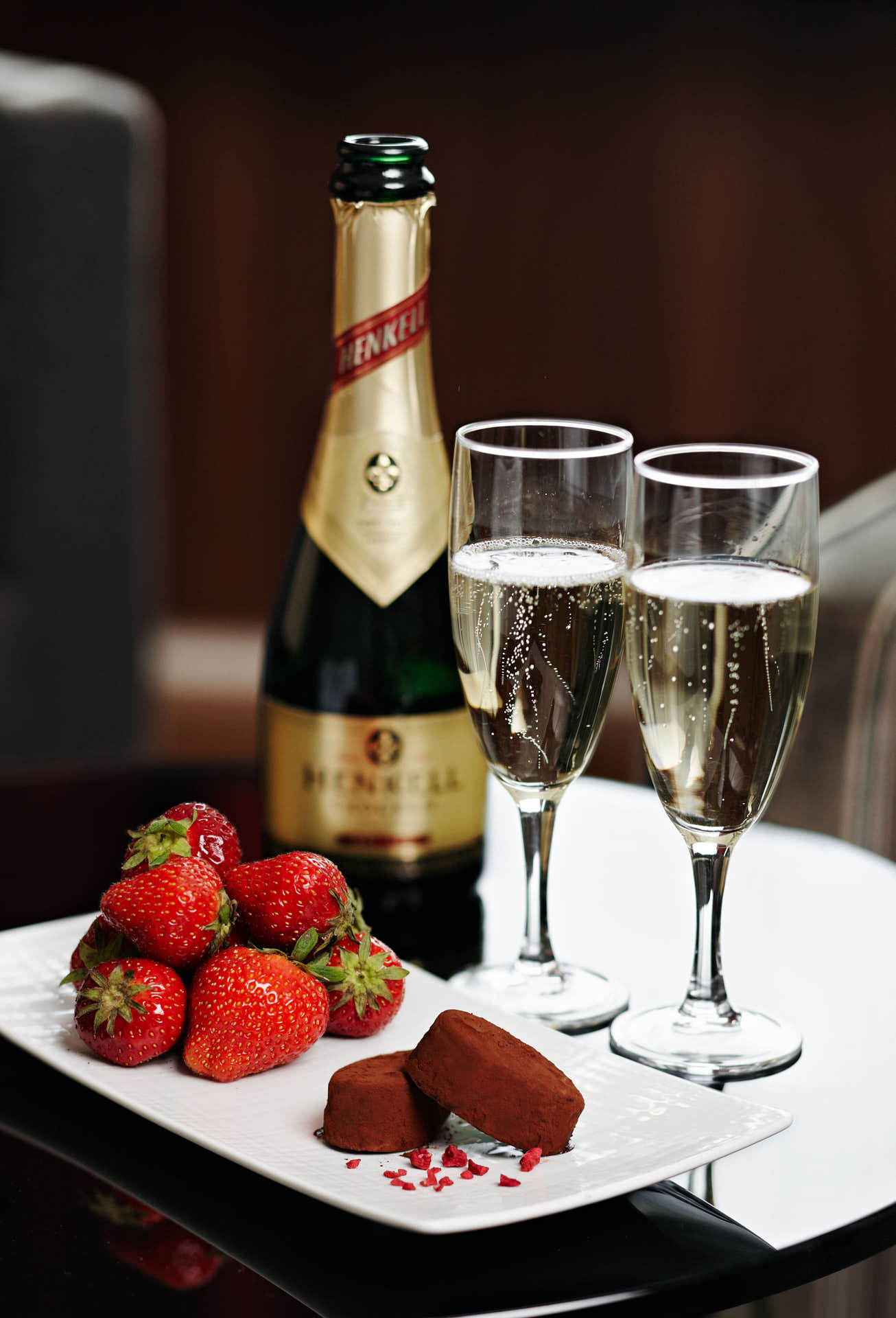 Solna Park Inn, hotellsvit i svart, brun och guldfärger, Champagne med jordgubbar och choklad på bricka. Foto Martin Ekwall