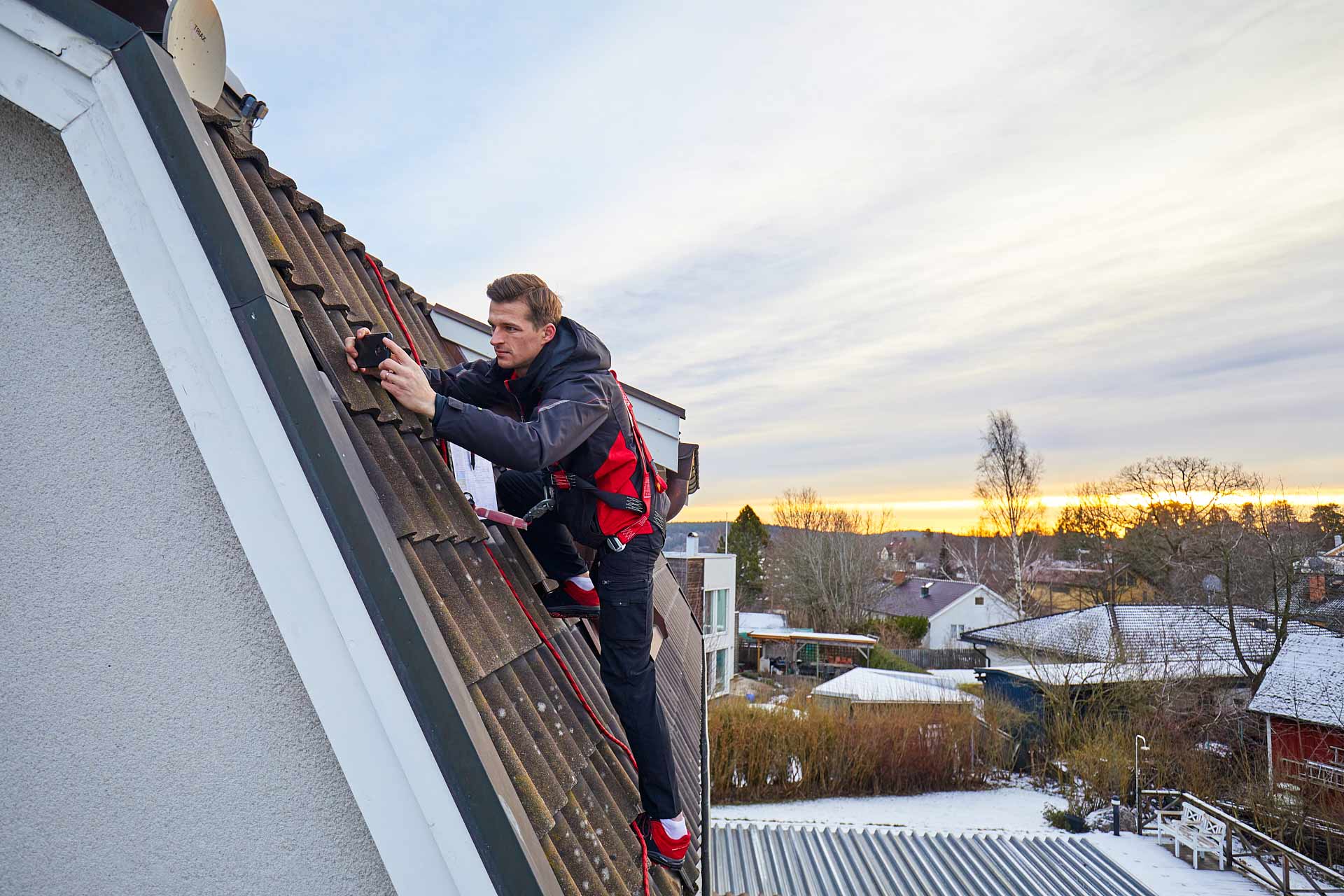 Offerträknare fotograferar vattbrädesbeslag vid vindskivan som dokumentation till offert. Foto Martin Ekwall.