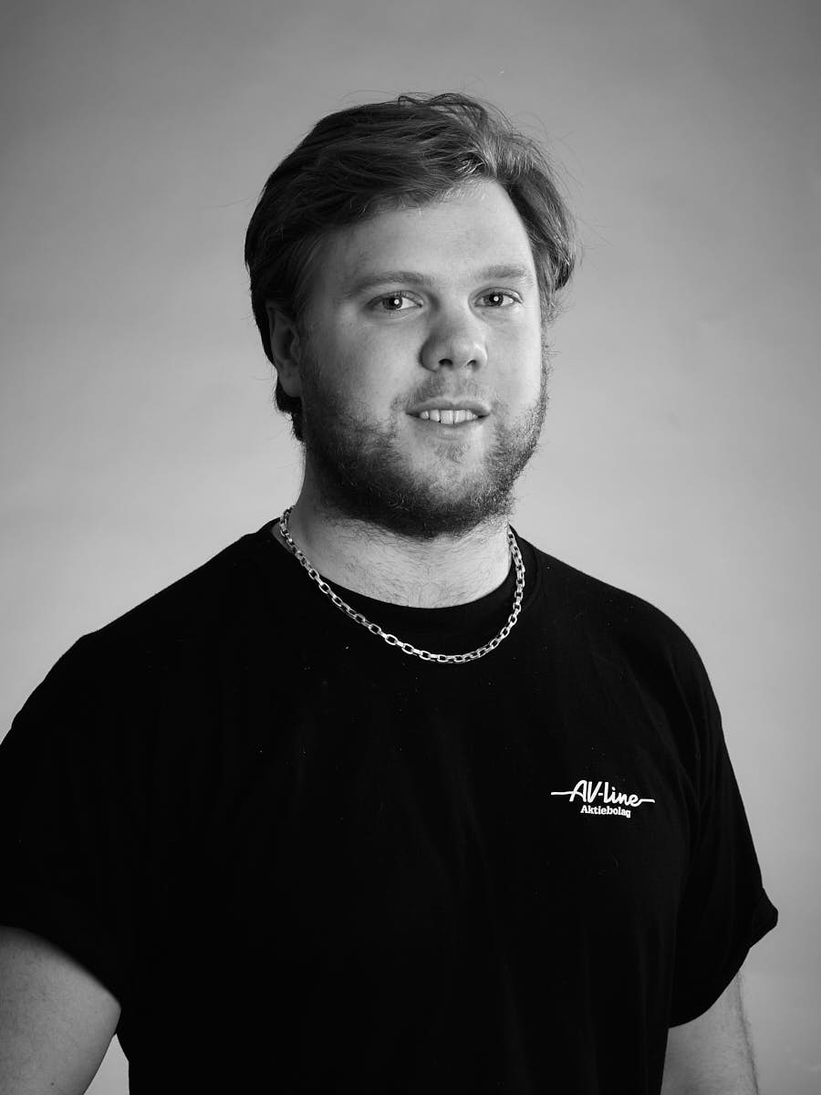 AV-Line porträtt av medarbetare i svart t-shirt mot grå bakgrund