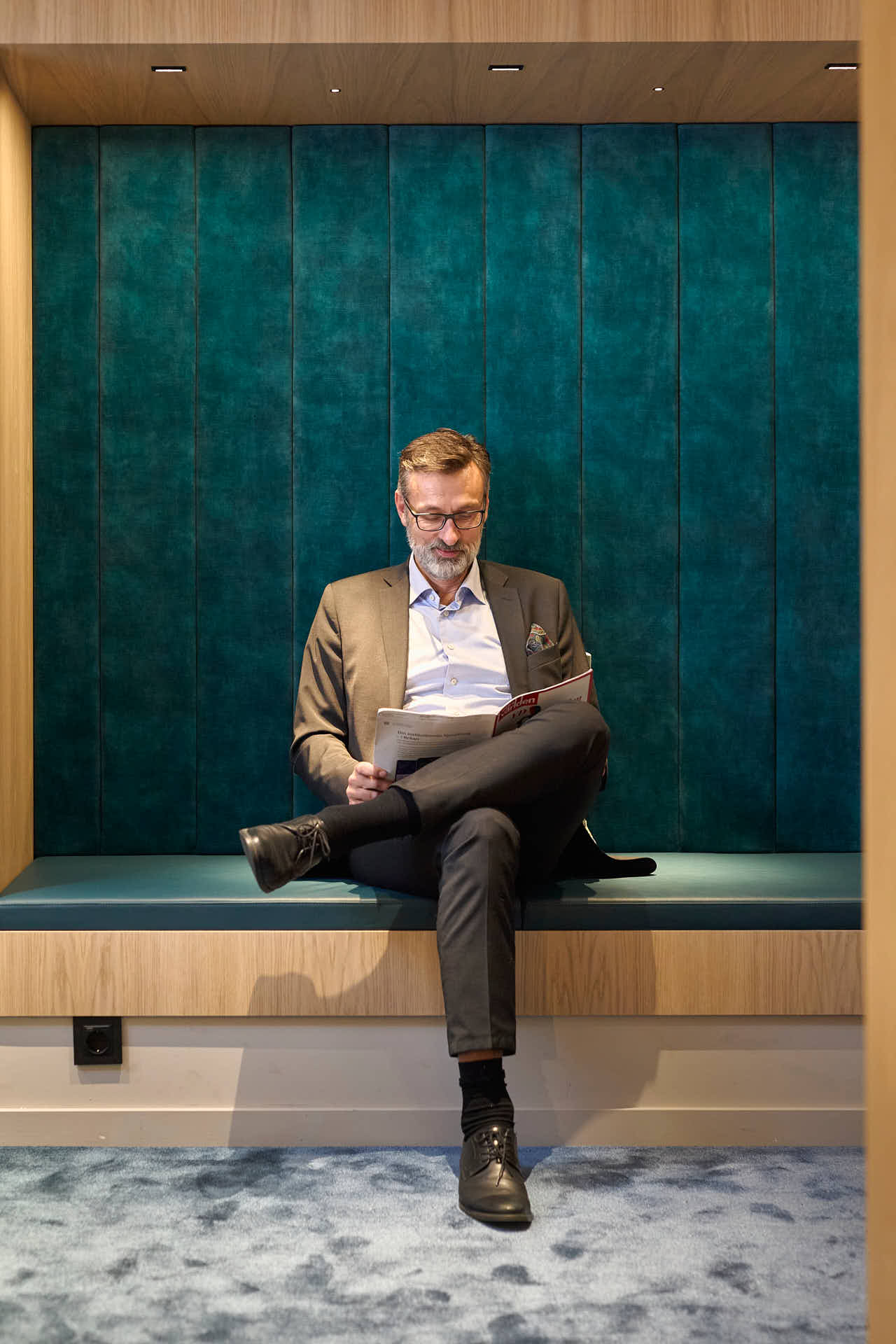 Case Kapitalförvaltning, Tom Andersson sitter och läser finanstidning, fotograferat av Martin Ekwall.