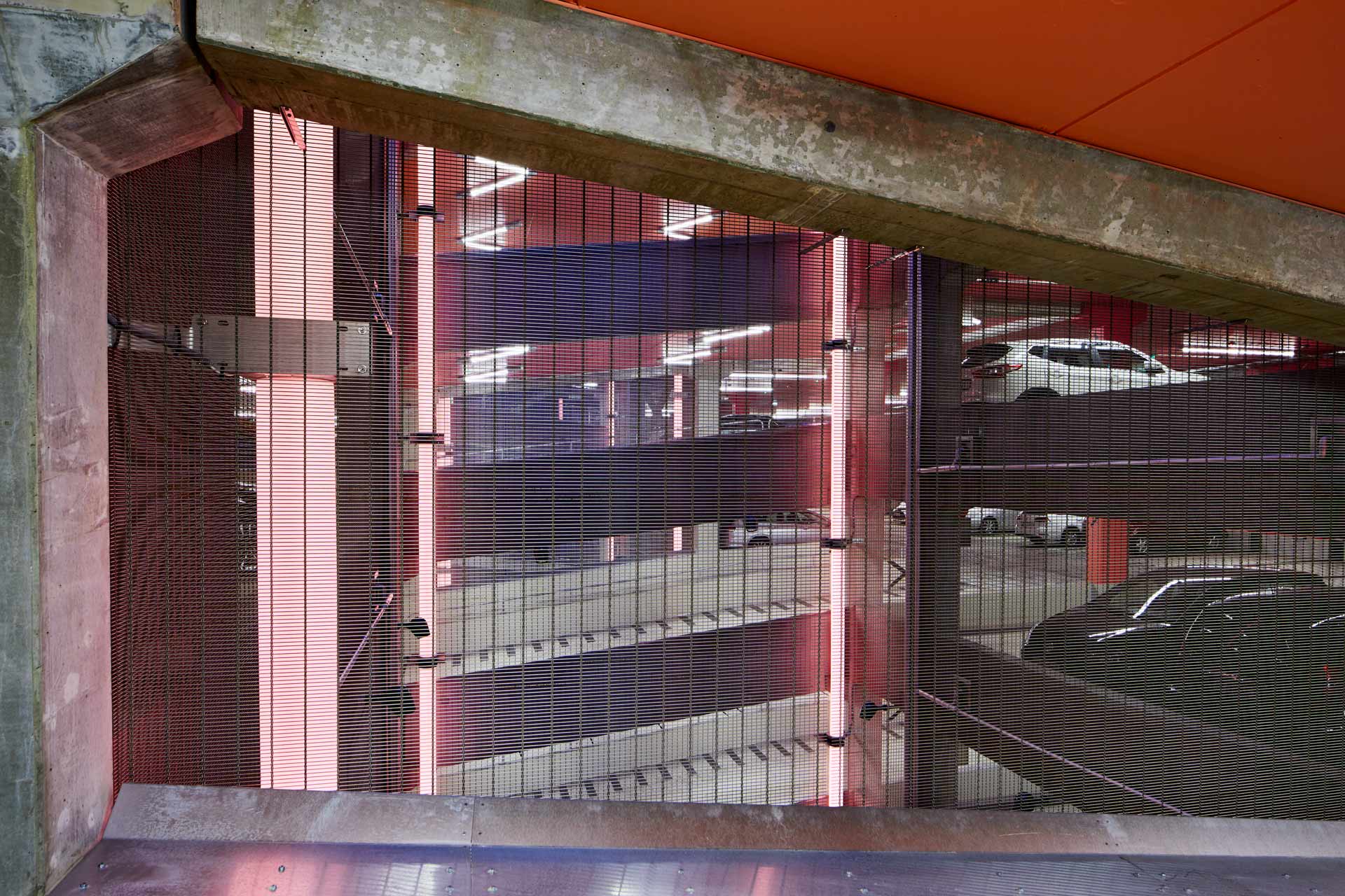 Parkeringshuset vid Mörby Centrum: parkeringsplan med ventilationsschakt och röda ledljusstavar som ljussätter interiören. Byggprojektlett av In3prenör. Foto Martin Ekwall.