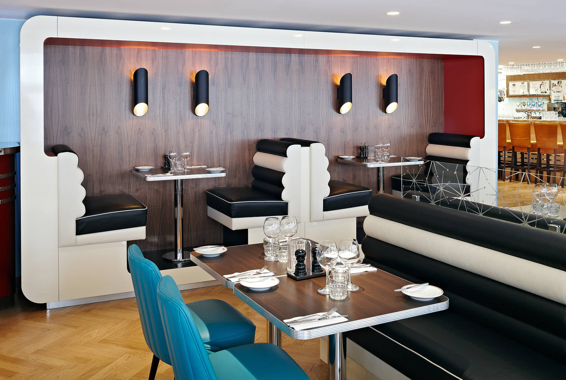 Retroinspirerade sittplatser med svartvita soffor i Marions Gastro restaurang. Spotlights och träpaneler i bakgrunden. Foto av Martin Ekwall för Co-Pilot.