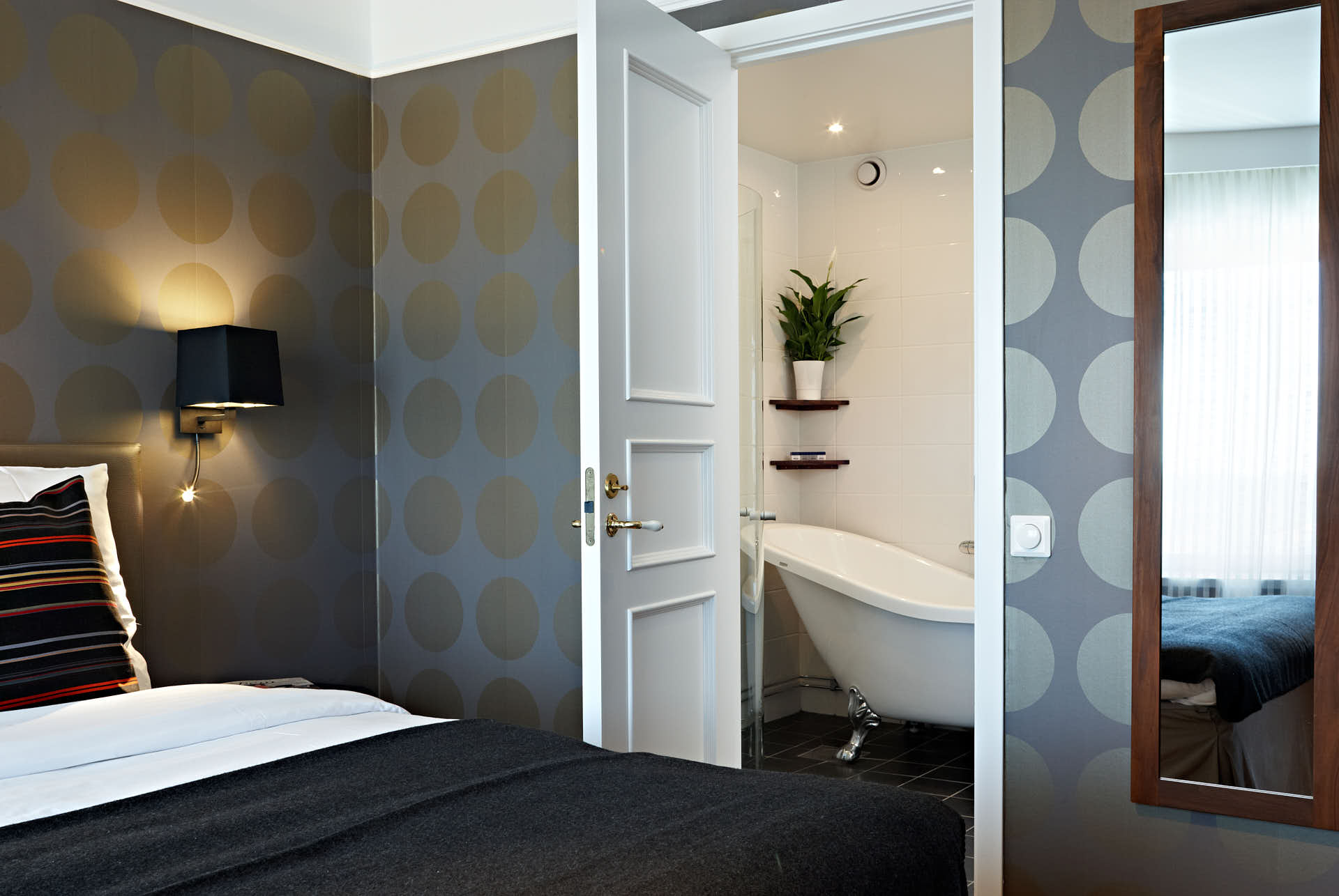Solna Park Inn, hotellsvit i svart,brun och guldfärger. Vy från sovrummet in mot badrummet. Foto Martin Ekwall