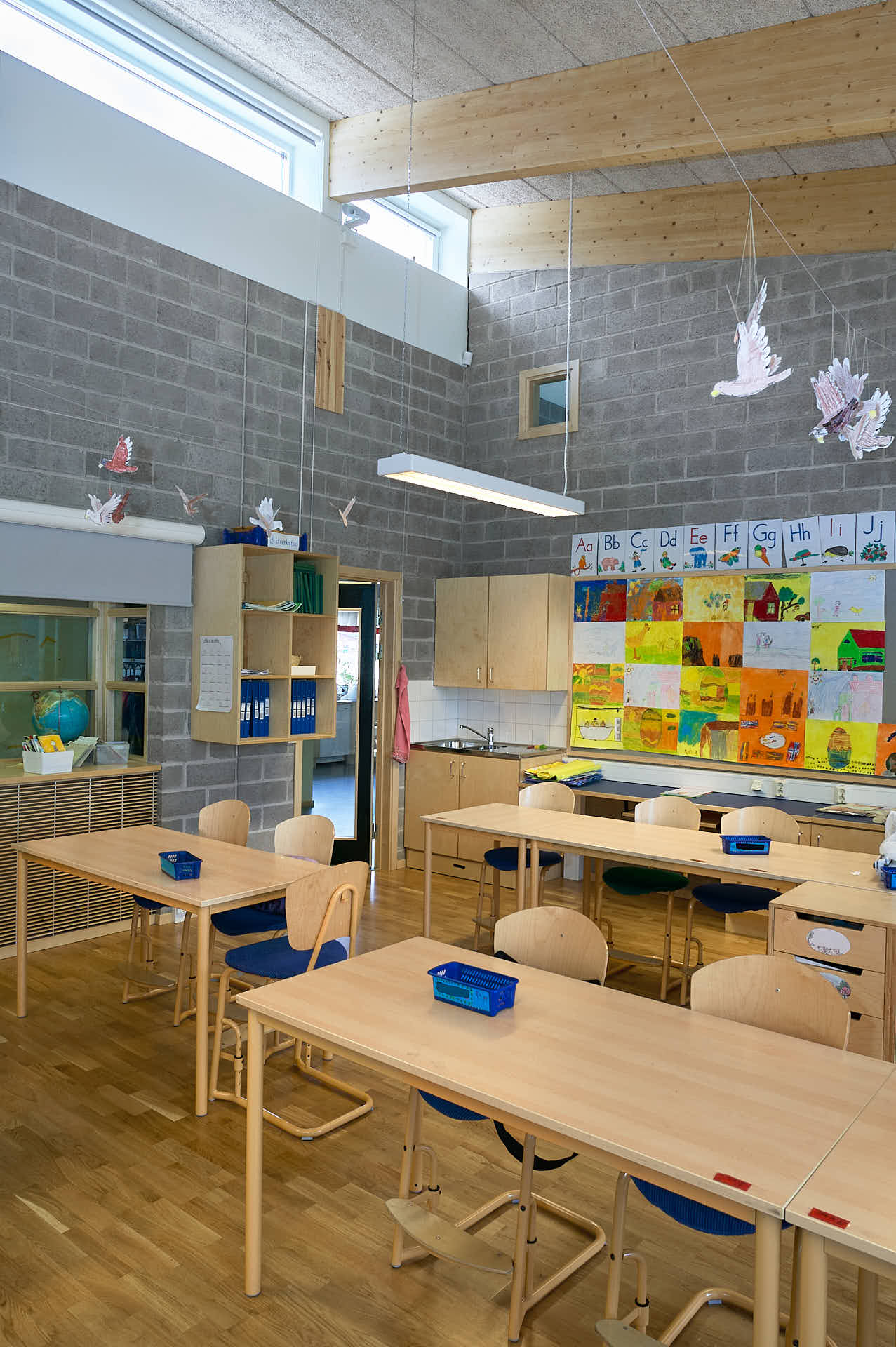Ljust klassrum i Brunns skola med ljusinsläpp nära taket. White Arkitekter ritade byggnaden och arkitekturfoto av Martin Ekwall..