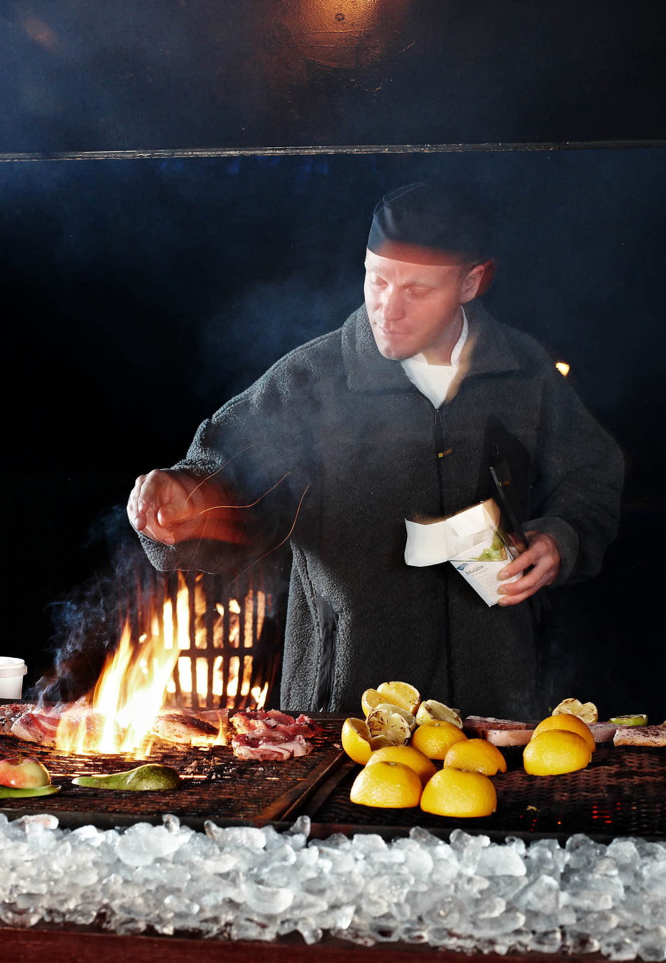 Grillkväll på Gällöfsta Herrgård i tema is och eld, kocken saltar över grillen i rörelse. Foto Martin Ekwall
