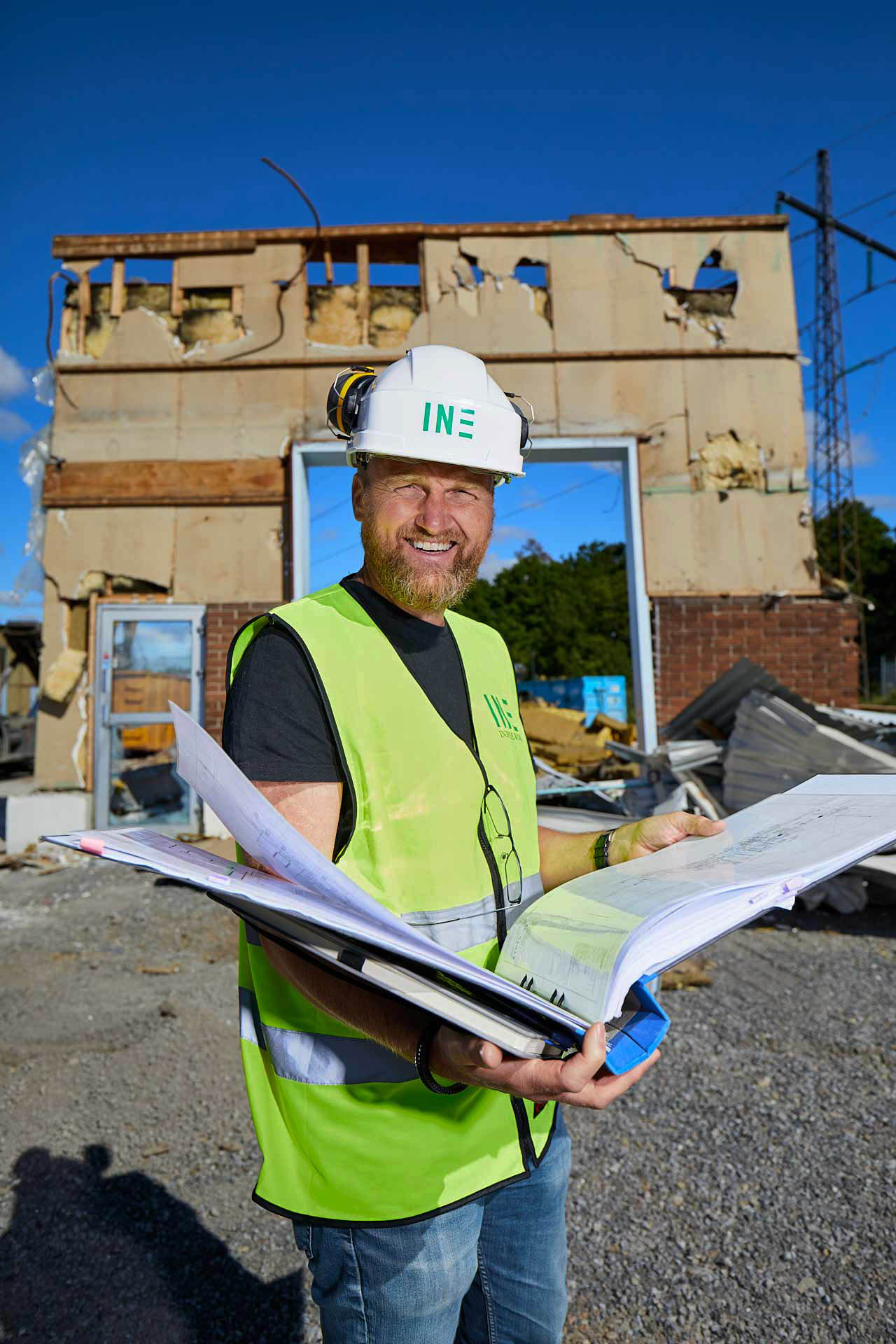 Medarbetare från In3prenör med pärm och ritningsunderlag på rivningsplats vid byggprojektledning av Opus. Foto Martin Ekwall.