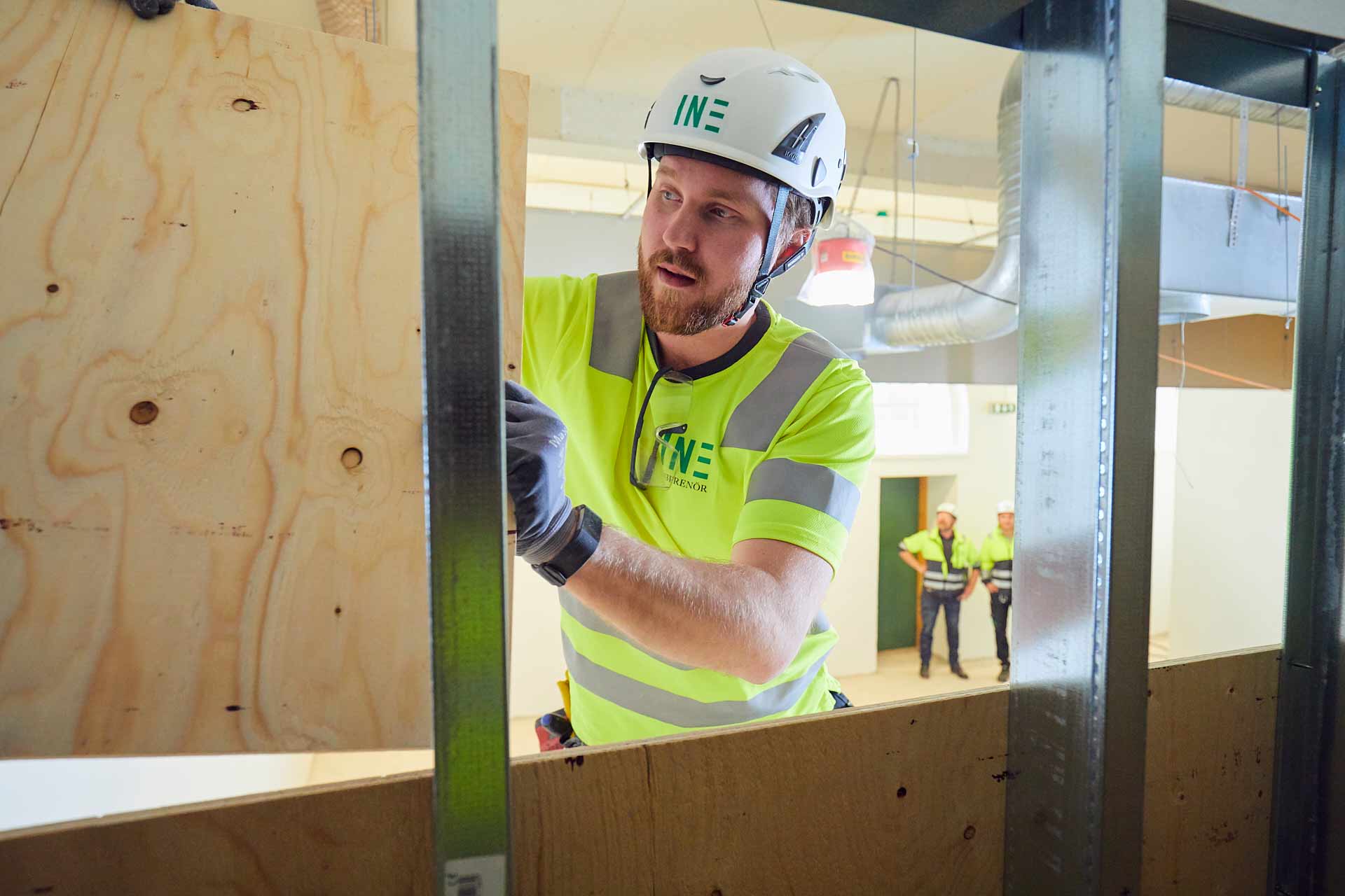 Medarbetare från In3prenör monterar av plywood/skivmaterial på byggarbetsplats inom byggprojektledning. Foto Martin Ekwall.